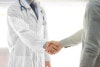 Doctor handshaking with patient in hospital